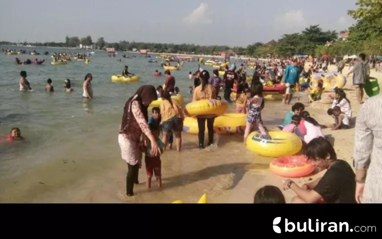 Wisatawan terlihat sedang bermain di Pantai Bandengan Jepara, Senin (7/4/2025)