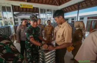 Seorang tentara Angkatan Darat Nasional Indonesia membagikan wadah makanan bergizi gratis (MBG) kepada seorang siswa di Sekolah Menengah Atas Negeri 20 di Bandung, Jawa Barat, Indonesia, pada 14 April 2025 silam.