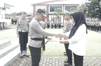 Kapolres Bitung Memberikan penghargaan kepada tiga personil atas dedikasi dan loyalitasnya dalam pelayanan terhadap Masyarakat