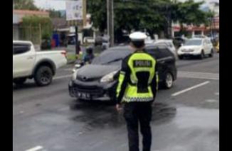 Foto Personel Polresta Manado Lakukan Pengaturan Lalu Lintas, Wujudkan Kelancaran dan Keamanan di Jalan Raya