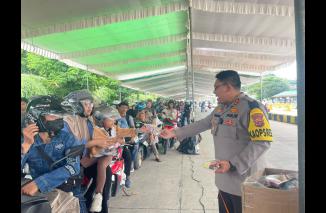 Foto Polisi Sambangi Pemudik Roda Dua, Bagikan Susu dan Eskrim untuk Anak